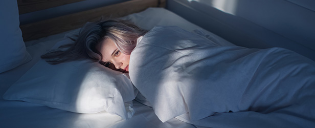 Person lies awake in bed.