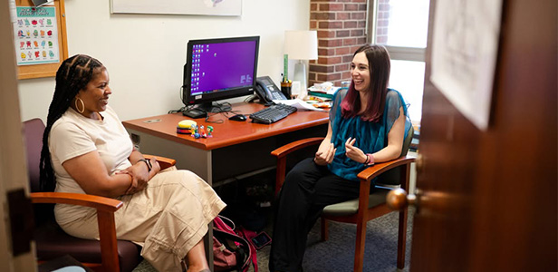 Two people speak in office.